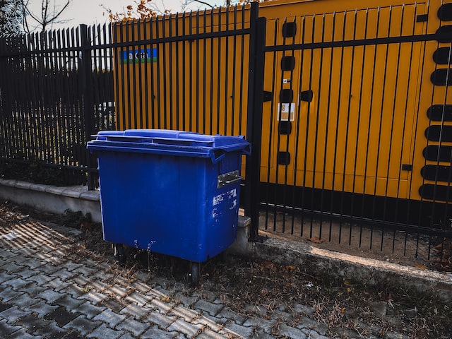 blue dumpster near the fence